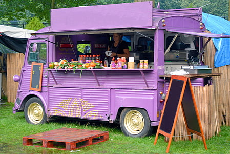 woman inside purple food truck near wooden fence during daytime thumbnail