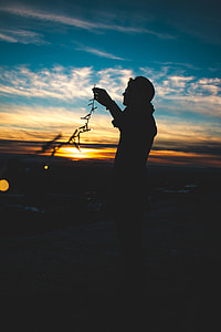 silhouette of man holding string lights thumbnail
