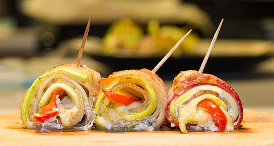 three rolled bacon with vegetables on brown wooden surface taken at daytime thumbnail