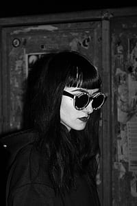 grayscale photo of woman in glasses and hoodie thumbnail