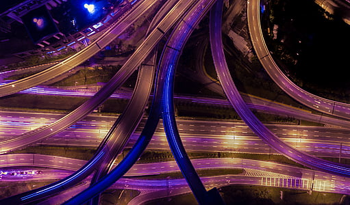 time-lapse photography of vehicles passing on road at night time thumbnail