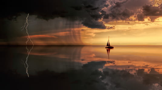 silhouette photo of ship on sea under nimbus clouds thumbnail