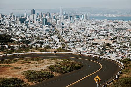 people skateboarding on grey concrete curved road near city thumbnail