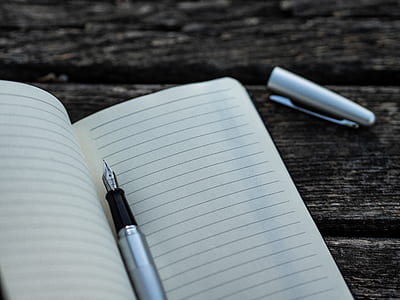 grey fountain pen on black lined notebook thumbnail