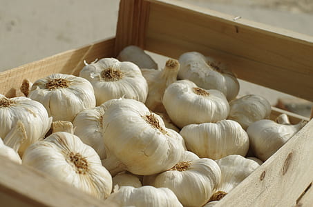 white garlic clove lot in wooden crate during daytime thumbnail