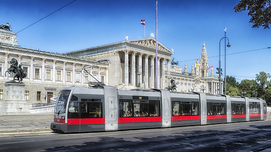 gray electric train near gray concrete building thumbnail