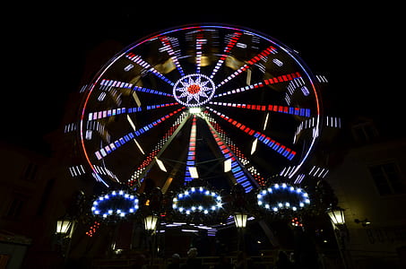 lighted black and red ferris wheel at nighttime thumbnail