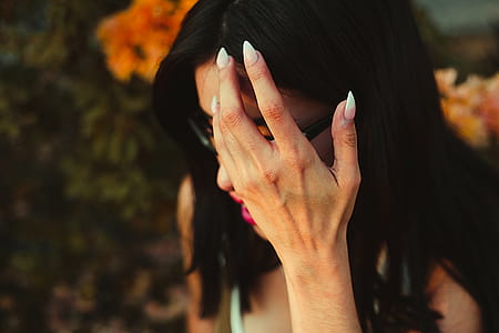 Woman in Green Sleeveless Top Covering Face thumbnail