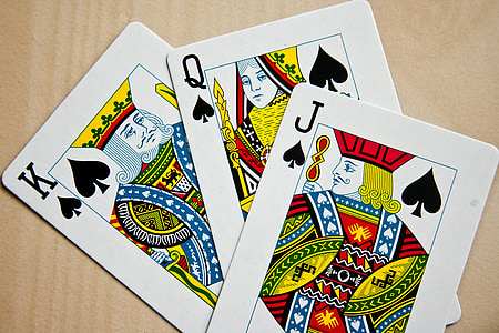three King, Queen, and Jack of Spade playing cards on beige surface thumbnail