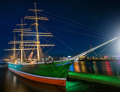 red and green sailing ship on body of water thumbnail