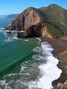 photo of green mountain near ocean thumbnail