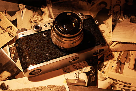 black SLR camera lying on photos thumbnail