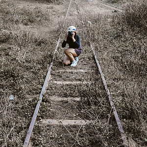 Woman White Round Hat Holding Black Dslr Camera on Rail Way thumbnail
