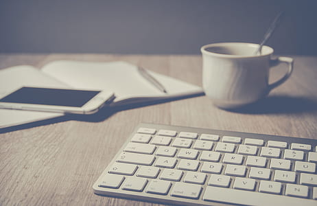 photo of white cup beside keyboard and smartphone thumbnail