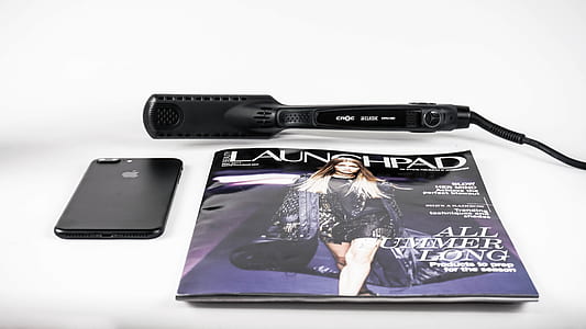 black hair straightener beside post-2017 iPhone thumbnail