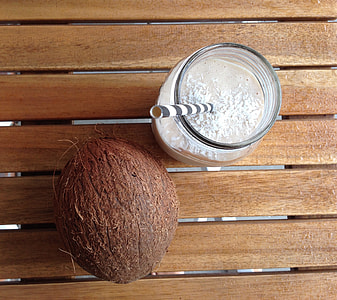 coconut shell beside clear glass jar on brown wooden surface thumbnail