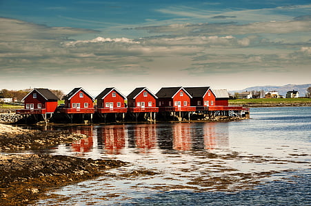 six red houses near body of water under blue cloudy sky thumbnail