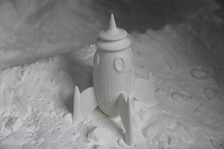 white rocket figurine on white sand thumbnail