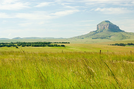 green grass field and mountain at distance thumbnail