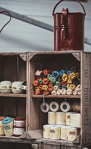 red steel bucket on top of wooden rack thumbnail