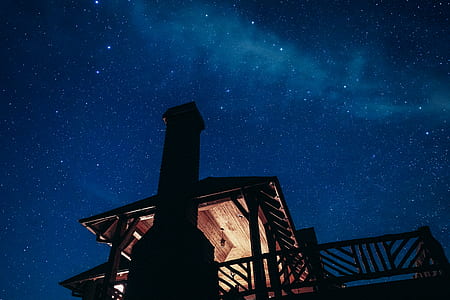 silhouette photo of wooden house under starry night thumbnail