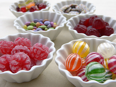 selective photography of assorted candies in ceramic bowls thumbnail