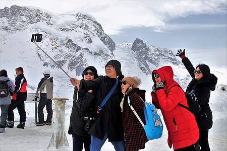 group of people taking groupie near mountain covered with snow thumbnail