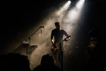 Man Playing Guitar in Front of People thumbnail