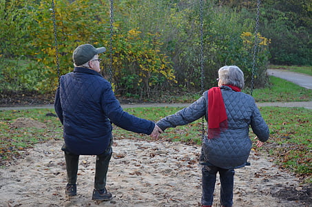 man and woman wearing black jacket holding hand while sitting thumbnail
