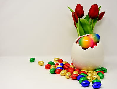 assorted-color eggs beside white vase thumbnail