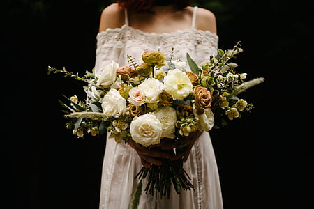 photo of woman holding bouquet of white petaled flowers thumbnail