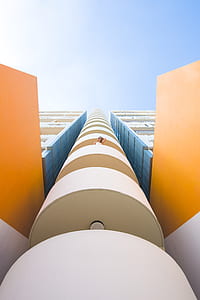 low angle photography of woman wearing white top standing on white terrace thumbnail