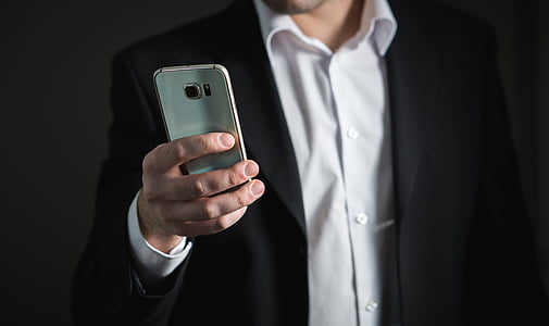 person holding silver Samsung Galaxy S6 thumbnail