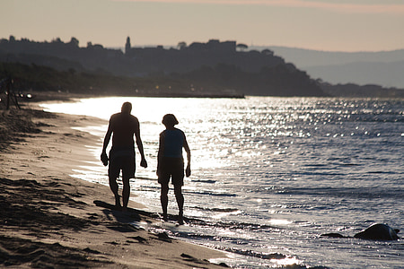 man and woman walking on seashore thumbnail