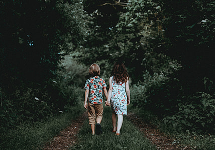 Siblings walking, holding hands thumbnail
