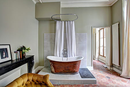 white and brown bathtub beside curtains thumbnail