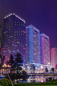 lighted buildings near body of water at night thumbnail
