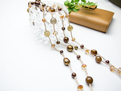 beaded brown accessory on white table thumbnail