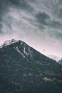 parachute on hill under gray clouds thumbnail