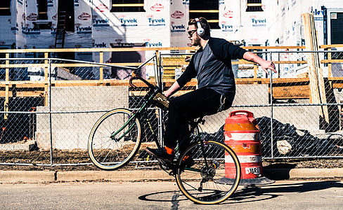 man riding bicycle beside building thumbnail