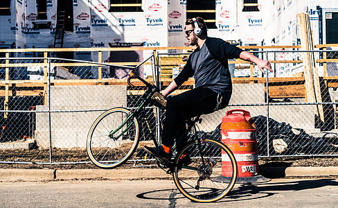 man riding a bicycle near chain link fence thumbnail