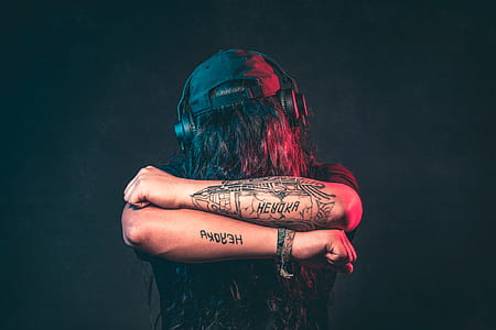 Man in Black Top Wearing Headphones Showing His Tattoos thumbnail