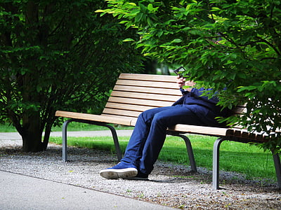 person wearing blue jeans sitting on bench thumbnail