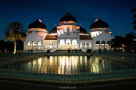white concrete temple near pool at night time thumbnail