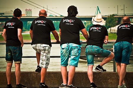 five men wearing the matching shirts standing on bridge thumbnail