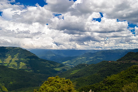 hills and trees under white clouds and blue sky thumbnail