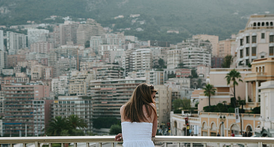 woman wearing white top while standing on balcony thumbnail