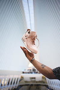 unpaired white Air Jordan 4 shoe above right human hand thumbnail