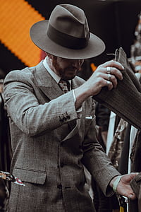 man with gray coat holding brown textile outdoor during daytime thumbnail