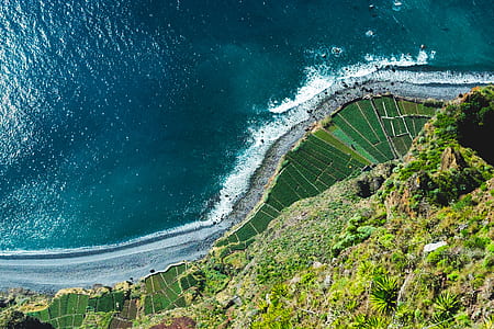 aerial view of body of water beside mountain thumbnail
